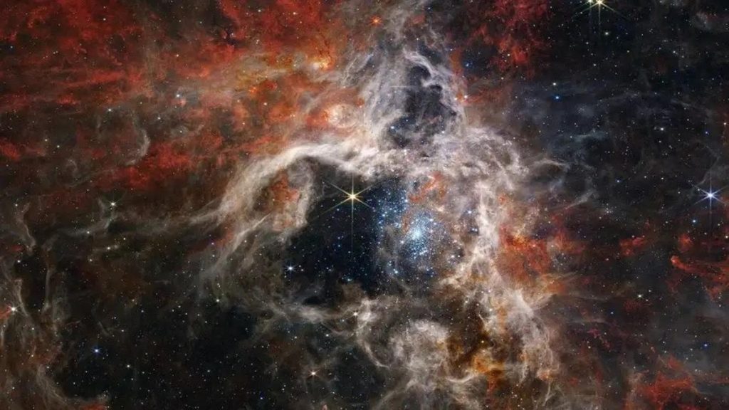 Telescopio espacial Webb captura imágenes de la 'seda de araña' de la nebulosa Tarántula 1 La Nebulosa de la Tarántula recibe su nombre por su apariencia, que es similar a la del agujero de una tarántula cubierta con seda de araña.