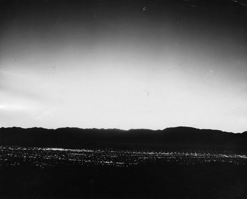 Atomic explosion as seen from the San Fernando Valley, March 7, 1955. "Atomic fire lights up Valley skies before dawn. The glowing light from the largest atomic explosion at Yucca Flats, Nevada, tests illuminate the Valley skies, 275 air miles away." at 5:20 a.m. today, 20 minutes after the explosion. The photo was taken from Mulholland Drive. The group of lights on the left is the Lockheed air terminal. To the right, Burbank's commercial and residential district." Photo credit: Bob Steele.