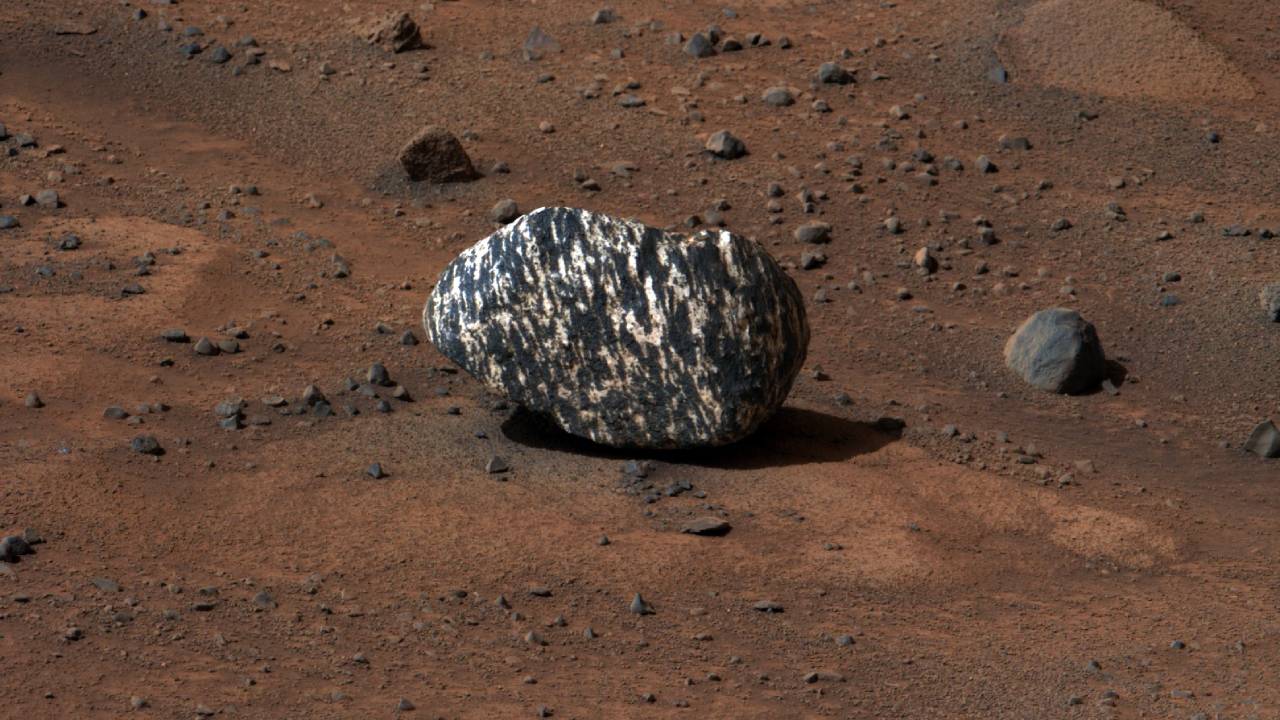 Encuentran en Marte el “Castillo de Freya”: una roca diferente a todo lo conocido El rover Perseverance de la NASA ha descubierto una roca en Marte que ha sorprendido tanto a científicos como a entusiastas del espacio. Bautizada como "Castillo de Freya", esta roca, encontrada el 13 de septiembre, destaca por ser "diferente a todo lo visto en Marte", lo que ha generado curiosidad y especulación sobre su origen y composición. El hallazgo del Castillo de Freya en Marte Marte continúa siendo un enigma para la humanidad. A pesar de todos los esfuerzos que se han hecho para desentrañar sus misterios, los expertos están de acuerdo en que aún no se sabe prácticamente nada del planeta rojo, eso se confirma con un nuevo y extraño hallazgo. El equipo de Perseverance detectó la roca en el cráter Jezero, una región marciana donde se cree que rocas fueron expulsadas debido al impacto de un asteroide. Mientras el rover ascendía lentamente hacia el borde del cráter, la cámara Mastcam-Z identificó una textura inusual en la distancia. Días después, al recibir los datos, los científicos se dieron cuenta de lo singular que era esta roca de 20 cm. Athanasios Klidaras, miembro del equipo de la NASA, explicó que la textura de la roca es única, posiblemente formada por procesos ígneos o metamórficos. Aunque informalmente se le llama "roca cebra" por sus rayas, los científicos sospechan que la roca pudo haberse desplazado desde otra ubicación, posiblemente rodando cuesta abajo. Exploración futura https://x.com/shasta721/status/1835116040155807891 El hecho de que Perseverance se dirija cuesta arriba es una señal alentadora para los investigadores, ya que esperan encontrar más rocas similares que ayuden a desentrañar el origen de esta enigmática formación. Conforme el rover continúa su misión en Marte, el Castillo de Freya se une a la lista de descubrimientos que desafían nuestras expectativas sobre el paisaje marciano. "Nuestro conocimiento de su composición química es limitado, pero las primeras interpretaciones indican que procesos ígneos y/o metamórficos podrían haber creado sus rayas". Explicó Klidaras. El descubrimiento del Castillo de Freya marca un momento emocionante en la exploración de Marte, abriendo nuevas interrogantes sobre los procesos geológicos del planeta rojo. A medida que Perseverance siga su camino, el equipo de la NASA espera obtener más información que permita comprender mejor el origen y la naturaleza de esta inusual formación. Referencia: Encuentran en Marte el “Castillo de Freya”: una roca diferente a todo lo conocido